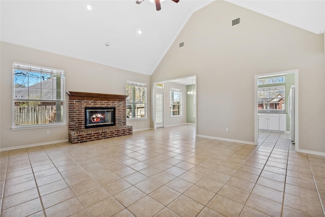 unfurnished living room featuring a fireplace, visible vents, a wealth of natural light, and light tile patterned flooring