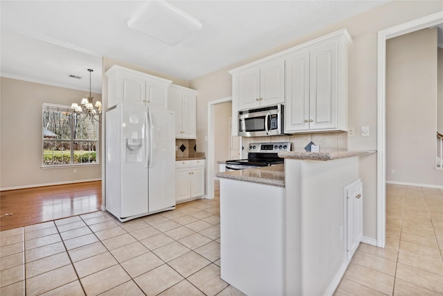 kitchen with appliances with stainless steel finishes, backsplash, white cabinetry, a notable chandelier, and light tile patterned flooring