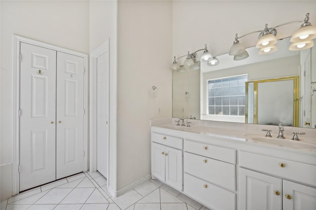 full bathroom featuring double vanity, tile patterned flooring, a sink, and a shower stall