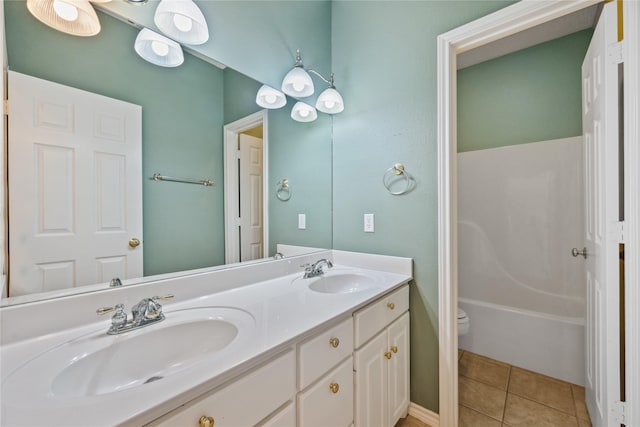 bathroom with double vanity, tile patterned flooring, a sink, and toilet