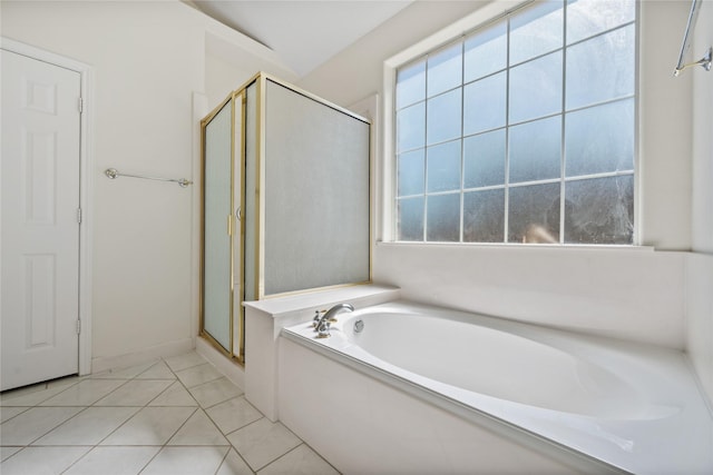 bathroom featuring a stall shower, tile patterned floors, a bath, and a healthy amount of sunlight