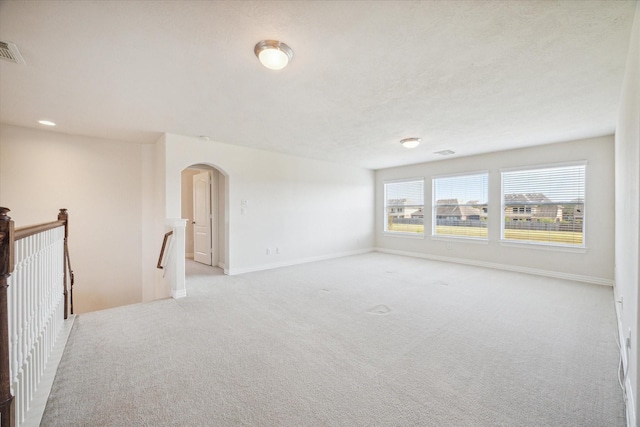 unfurnished room with light carpet and a textured ceiling