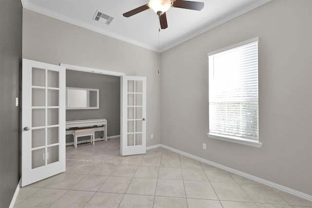 spare room featuring french doors, ceiling fan, crown molding, and light tile patterned floors