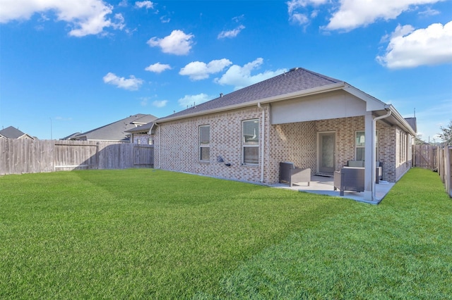 rear view of property with a yard and a patio area