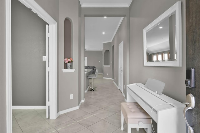 hallway with ornamental molding and light tile patterned floors