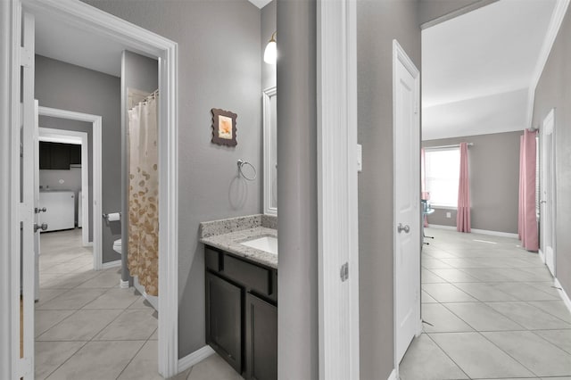 bathroom with vanity, washer / dryer, tile patterned floors, and toilet