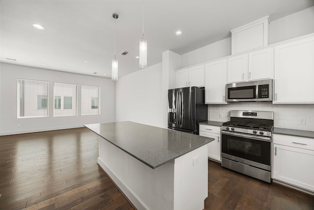 kitchen featuring tasteful backsplash, hanging light fixtures, stainless steel appliances, and white cabinets