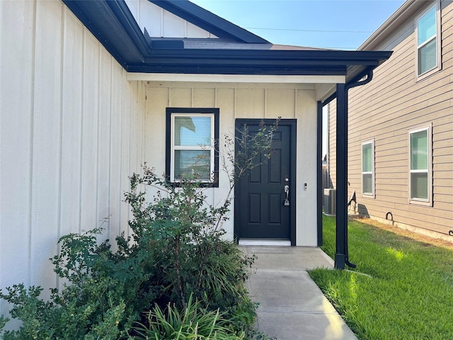 property entrance featuring a yard and central air condition unit