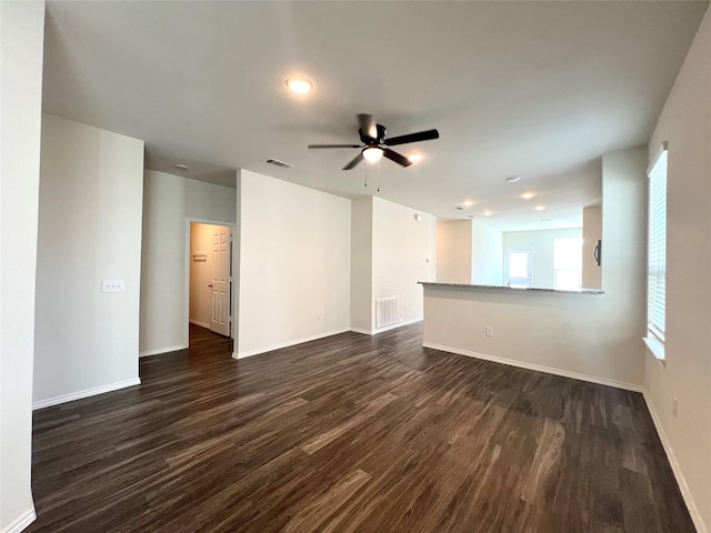 unfurnished living room with dark hardwood / wood-style floors and ceiling fan