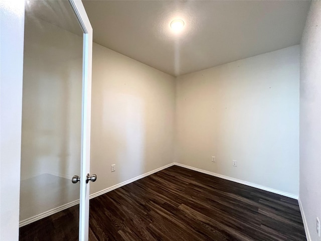 unfurnished room with dark wood-type flooring