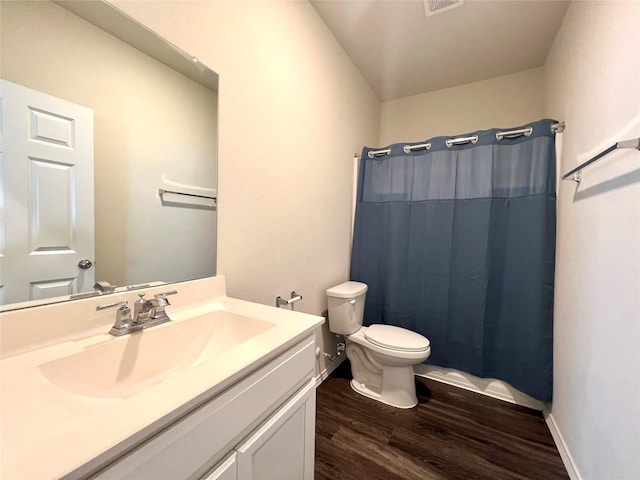 bathroom with vanity, hardwood / wood-style flooring, toilet, and walk in shower