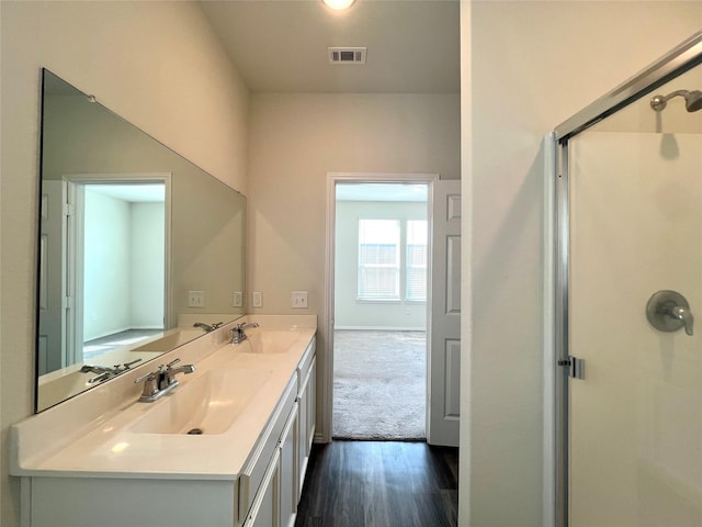 bathroom with vanity, an enclosed shower, and hardwood / wood-style floors