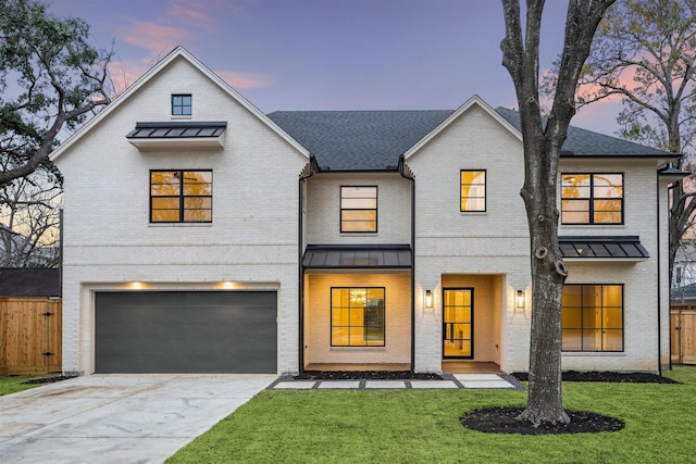 modern inspired farmhouse featuring a garage and a lawn