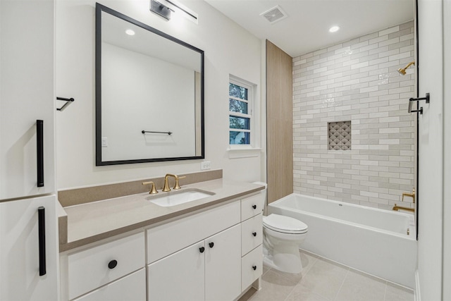 full bathroom with tile patterned flooring, vanity, tiled shower / bath, and toilet