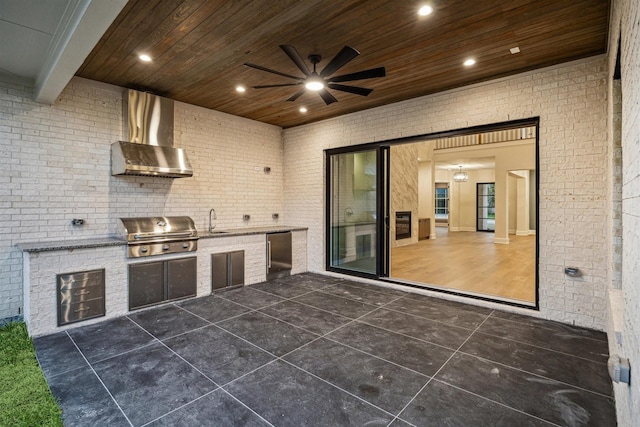 view of patio with ceiling fan, an outdoor kitchen, a grill, and sink