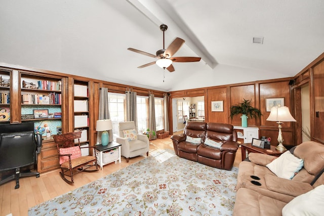 living room with vaulted ceiling with beams, light hardwood / wood-style floors, ceiling fan, and wood walls