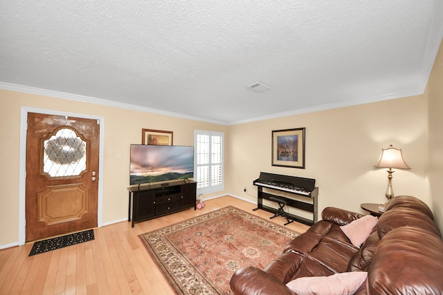 living room featuring crown molding, a textured ceiling, and light wood-type flooring