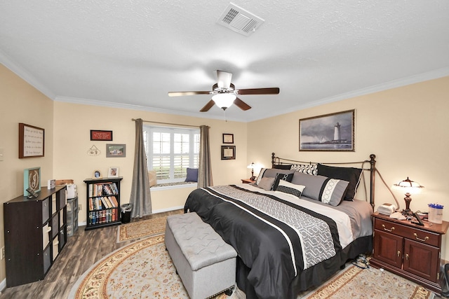 bedroom with crown molding, ceiling fan, hardwood / wood-style flooring, and a textured ceiling