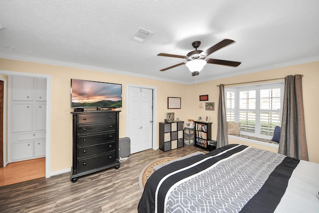 bedroom with wood-type flooring, ornamental molding, and a textured ceiling