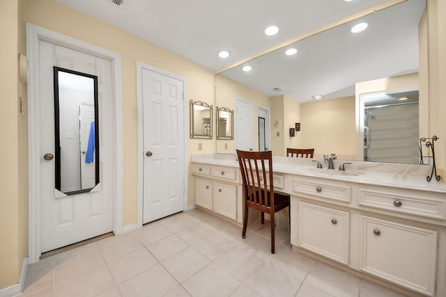 bathroom with walk in shower, vanity, and tile patterned flooring