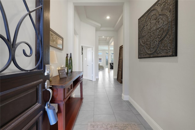 hallway with recessed lighting, baseboards, and light tile patterned floors