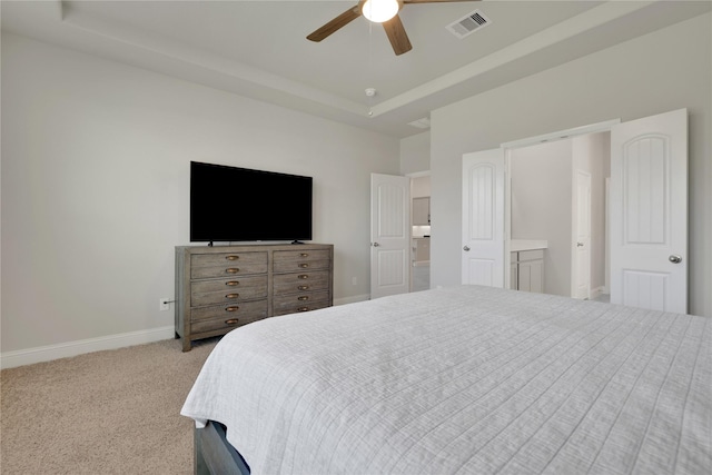 bedroom featuring carpet flooring, visible vents, a ceiling fan, baseboards, and a tray ceiling