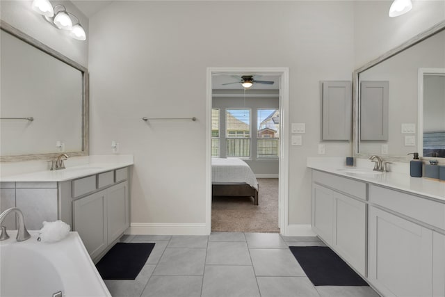 ensuite bathroom featuring two vanities, tile patterned flooring, and a sink