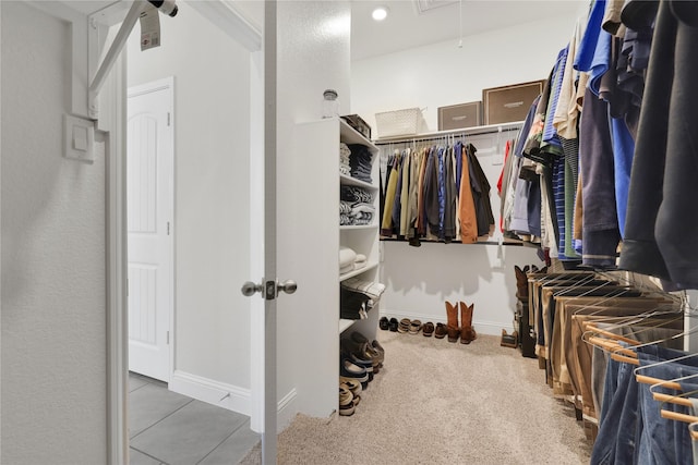 walk in closet with carpet flooring and attic access