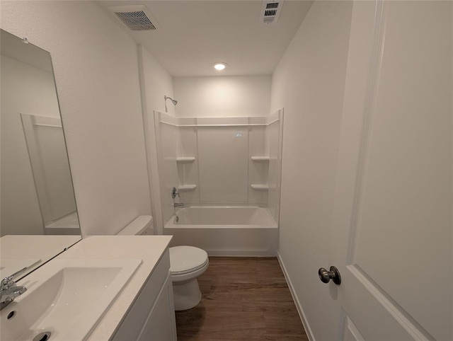 full bathroom featuring hardwood / wood-style flooring, vanity, washtub / shower combination, and toilet