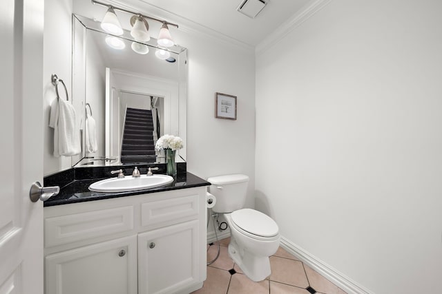 bathroom featuring tile patterned flooring, vanity, crown molding, and toilet