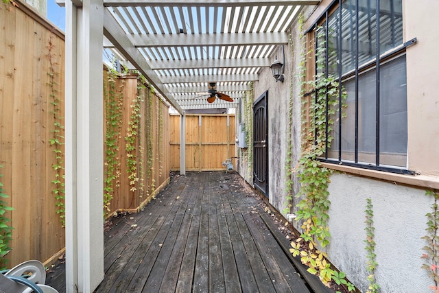 wooden deck featuring ceiling fan and a pergola