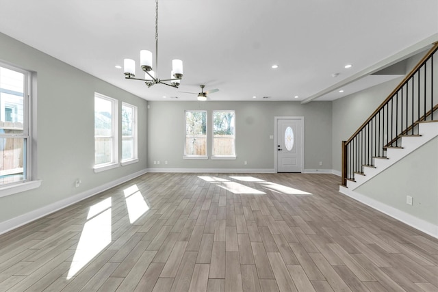 interior space featuring ceiling fan with notable chandelier and light wood-type flooring