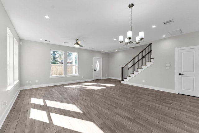 unfurnished living room with hardwood / wood-style floors and ceiling fan with notable chandelier