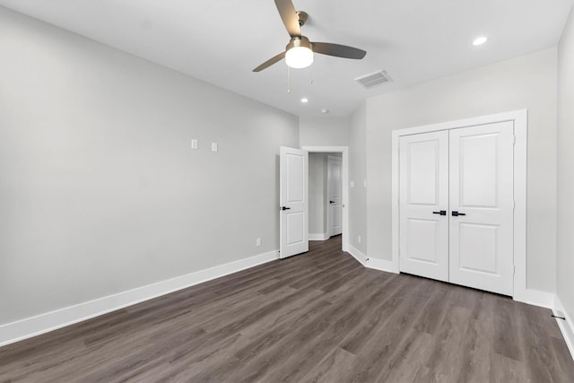 unfurnished bedroom with ceiling fan, dark hardwood / wood-style floors, and a closet