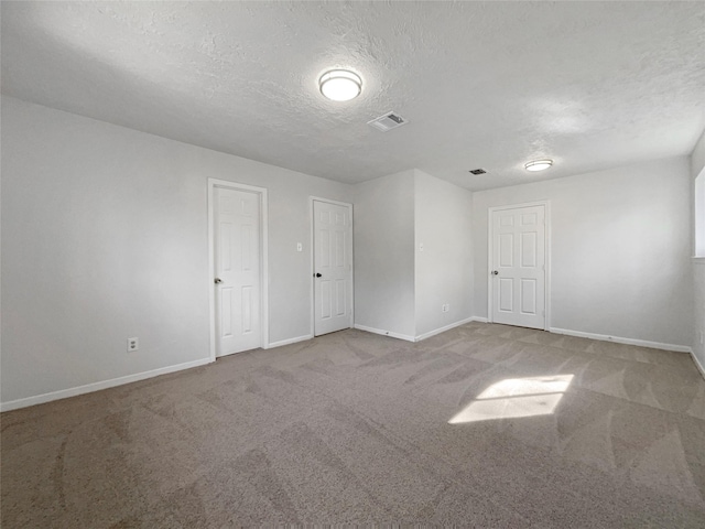 empty room featuring carpet flooring and a textured ceiling