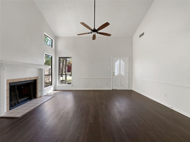 unfurnished living room featuring ceiling fan, high vaulted ceiling, a fireplace, wood-type flooring, and a textured ceiling