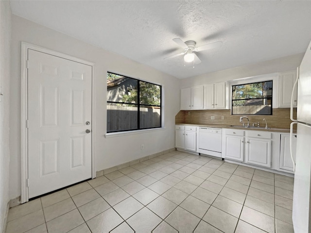 kitchen featuring sink, white cabinets, decorative backsplash, a healthy amount of sunlight, and white appliances