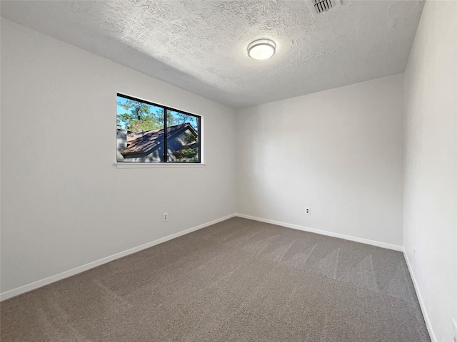 carpeted spare room with a textured ceiling