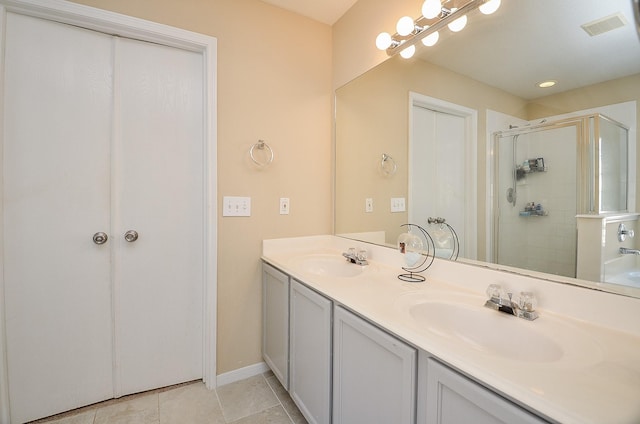 bathroom featuring a shower with door, vanity, and tile patterned flooring