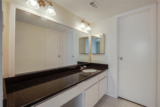 bathroom featuring tile patterned floors, a textured ceiling, and vanity