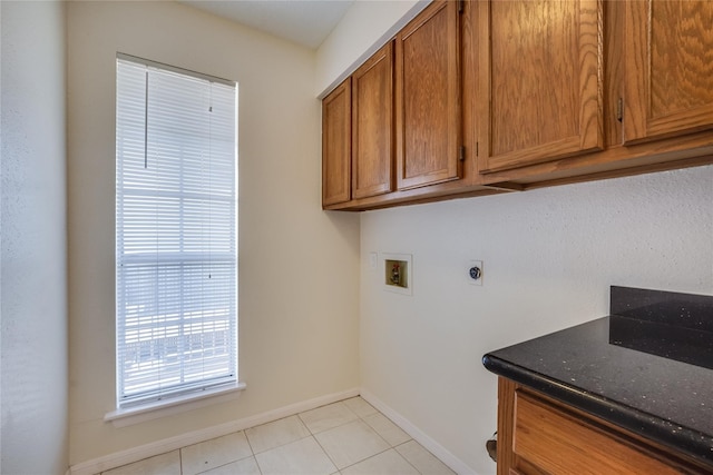 clothes washing area featuring cabinets, washer hookup, light tile patterned floors, and electric dryer hookup