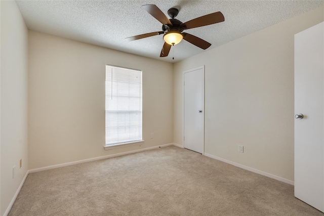 unfurnished room featuring ceiling fan, light carpet, and a textured ceiling