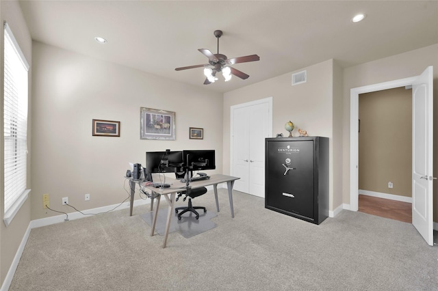 office space featuring plenty of natural light, light carpet, and ceiling fan