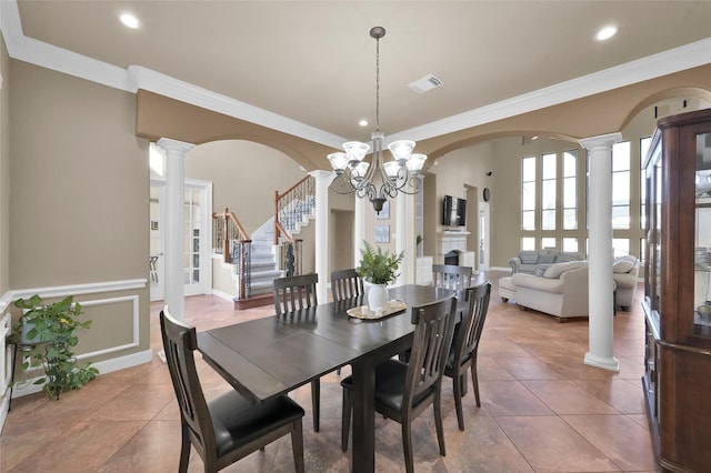 tiled dining area featuring ornamental molding, decorative columns, and a chandelier