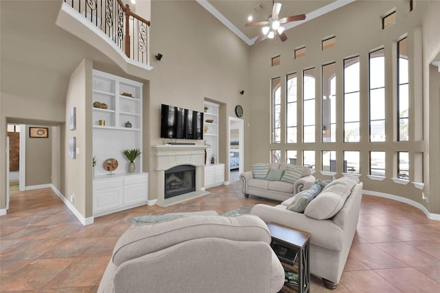 tiled living room featuring crown molding, a towering ceiling, ceiling fan, and built in shelves