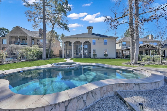 view of pool with an in ground hot tub and a lawn