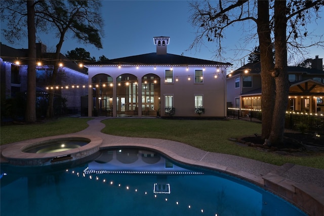 view of swimming pool featuring an in ground hot tub and a lawn