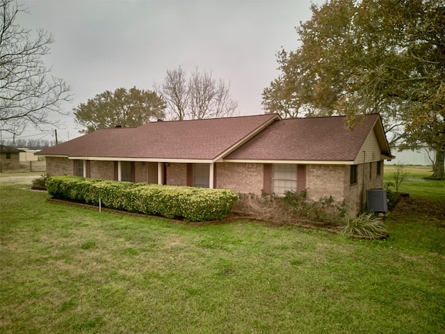 view of front of house featuring a front yard and central air condition unit