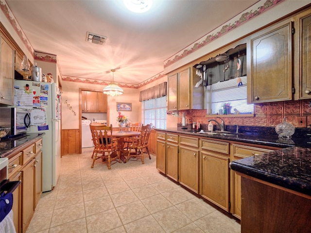 kitchen with sink, separate washer and dryer, white fridge, pendant lighting, and decorative backsplash