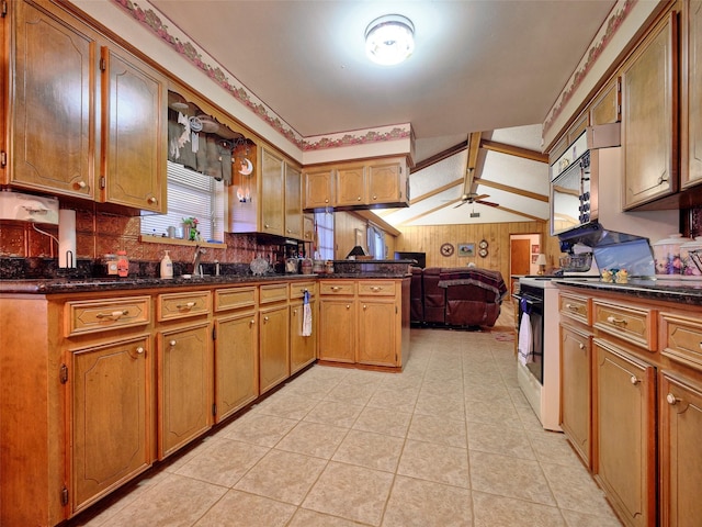 kitchen featuring electric stove, sink, ceiling fan, vaulted ceiling, and kitchen peninsula